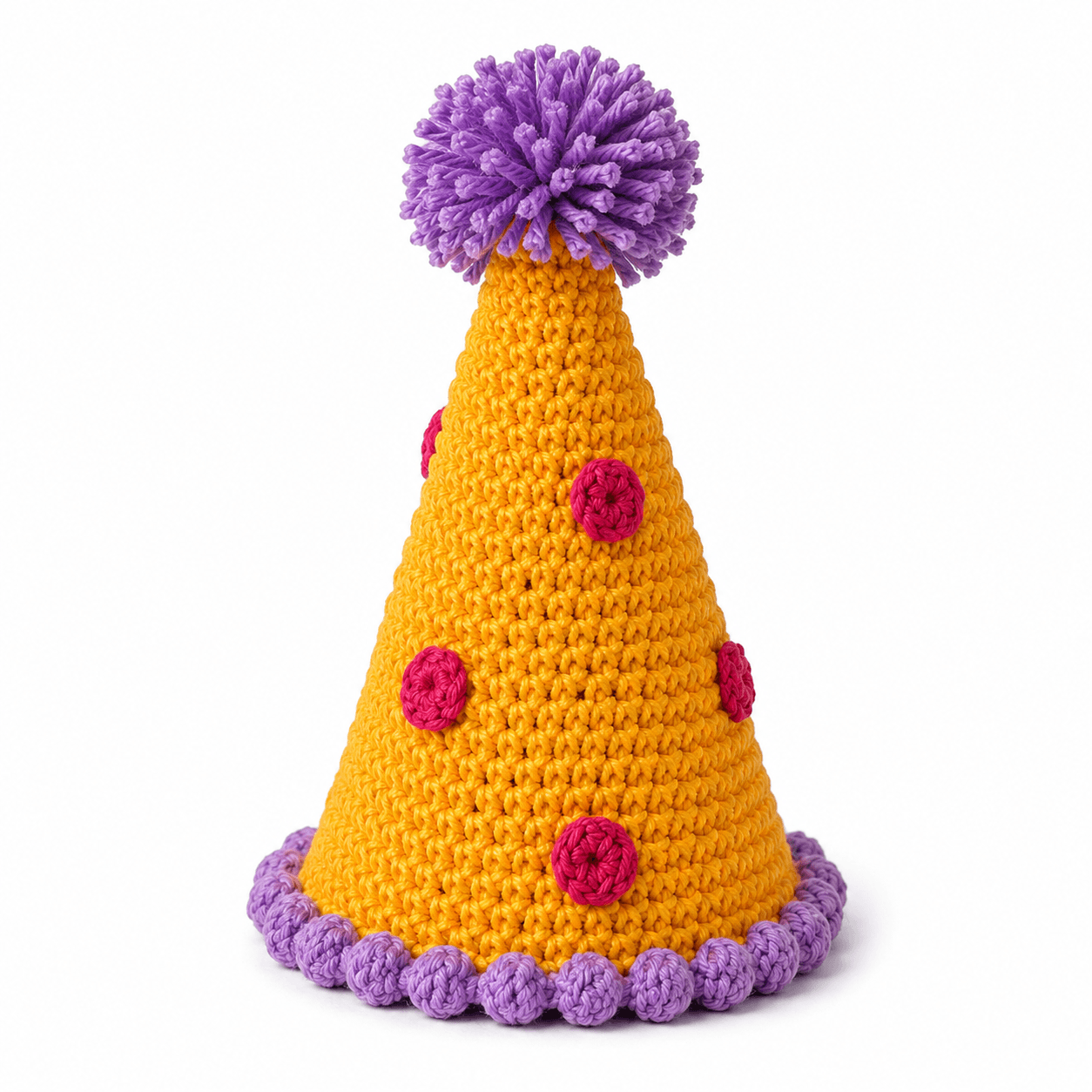 A single handmade Cutesy & Twee pompom party hat in marigold and purple yarn, on a plain studio background